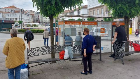 Personas esperando este martes por el autobús de  A Coruña en la parada de Betanzos
