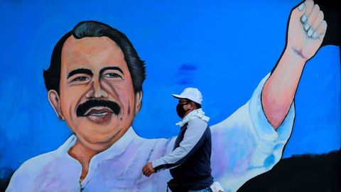 Un hombre pasa por un mural ensalzando al presidente Daniel Ortega