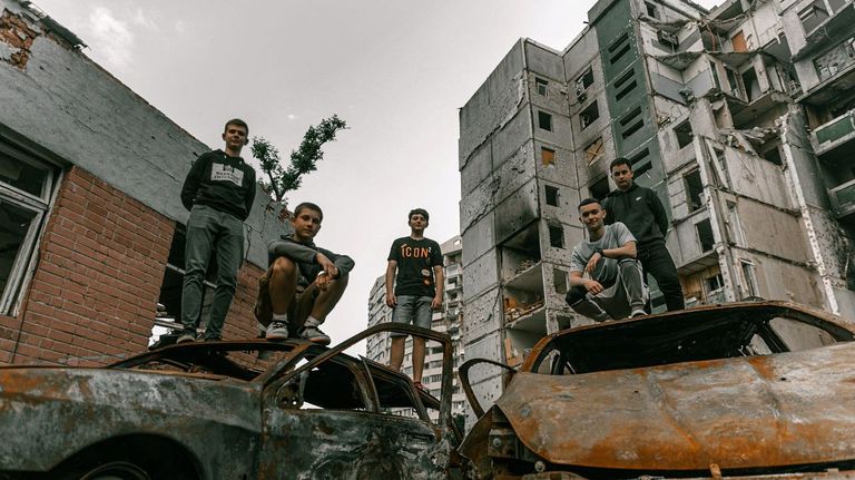 Un grupo de estudiantes posan ante un instituto de secundaria destruido en Chernígov (Ucrania)