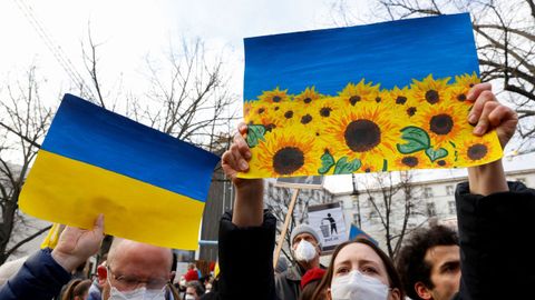 Unas personas sostienen pancartas con banderas ucranianas durante una protesta contra la guerra, después de que Rusia lanzara una operación militar masiva contra Ucrania, en Berlín, Alemania.