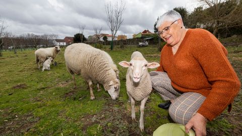 Marisol Soneira xunto as sas ovellas na sa horta de Camarias