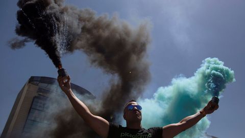 Un hombre sostiene latas de humo durante una manifestacin en contra de Uber en Madrid