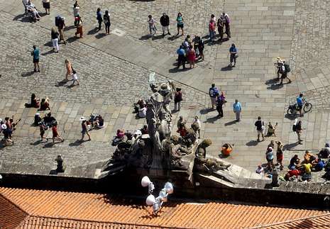 <span lang= es-es >Por tierra y aire</span>. Dos vistas a�reas de peregrinos, una en el Camino Franc�s, y la otra en el Obradoiro, con el tejado del pazo de Raxoi en primer t�rmino. Por tierra, los guardias civiles tienen ocasi�n de conocer las experiencias de los romeros durante su recorrido