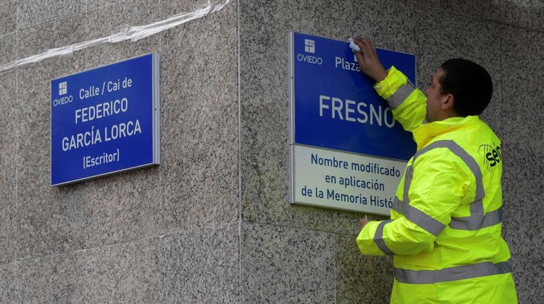 Un trabajador coloca las placas de la calle Federico García Lorca y de la plaza Fresno, en Oviedo, en aplicación de la Ley de la Memoria Histórica