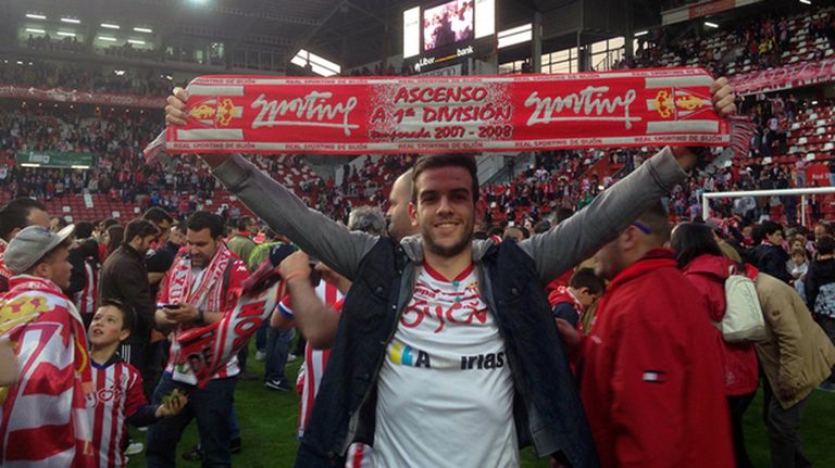 Un aficionado celebra la permanencia con la bufanda del Sporting sobre el césped de El Molinón