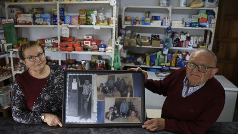 Rosa y José sostienen antiguas fotografías que decoran la taberna, en una de las que se le ve a él a la puerta del negocio, abierto en 1967
