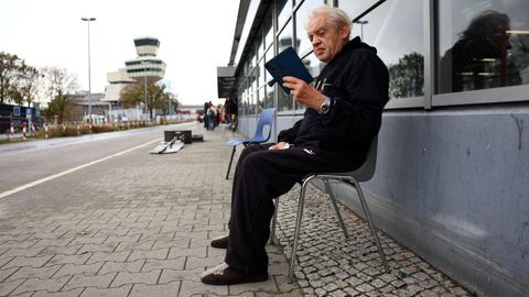 Un refugiado ucraniano consulta su teléfono en el antiguo aeropuerto berlinés de Tegel, transformado por las autoridades alemanas en un centro de acogida
