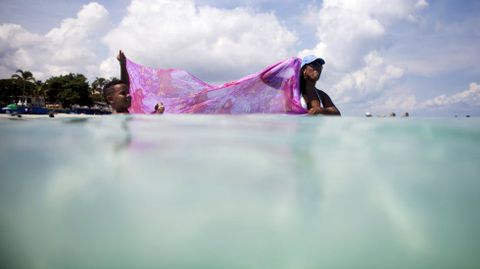 Dos cubanos tratan de pescar con una toalla en las aguas de Varadero (Cuba). 