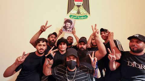 Seguidores del clérigo chií Al Sadr, este lunes, posando con una foto del líder religioso en el palacio presidencial de Bagdad