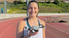 Claudia Rojo, en una pista de atletismo con un dron en sus manos.