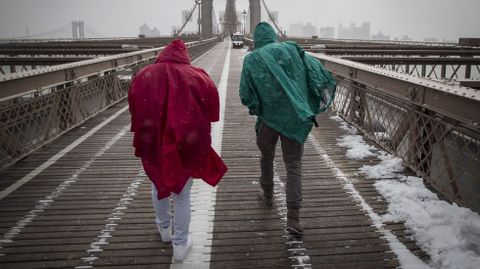 Dos turistas atravesando el puente de Brooklyn, en Nueva York. 
