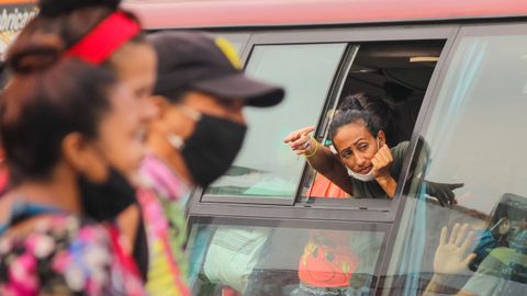 Una mujer se asoma por la ventana de un bus del operativo de retorno de desplazados venezolanos, en San Antonio del Táchira 