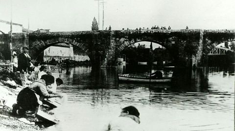 Un grupo de lavandeiras cerca del puente viejo, en una imagen de principios del siglo XX