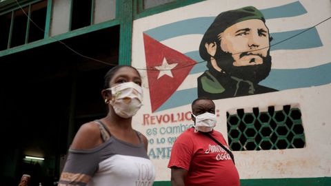 Gente pasa junto a una imagen del fallecido presidente cubano Fidel Castro, en La Habana, Cuba