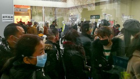 Las personas hacen cola para recibir tratamiento en el departamento ambulatorio de fiebre en el Hospital Wuhan Tongji en Wuhan, provincia de Hubei