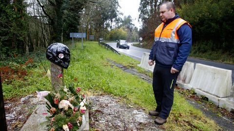 Javier Lois, jefe de Protección Civil de Cerdedo-Cotobade, ante una cruz a orillas de la N-541, en el lugar donde en el año 2020 falleció un motorista en un accidente.