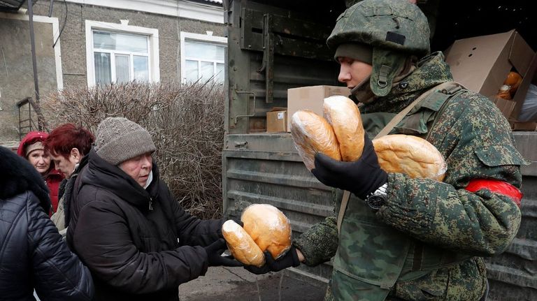 Un soldado prorruso reparte pan en una localidad de Donetsk controlada por los separatistas