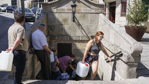 Vecinos de Ribadavia recogen agua en una fuente ante la escasez que sufre el abastecimiento municipal. 
