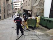 Los bomberos extinguen el fuego en una isla de contenedores frente a la Biblioteca Central