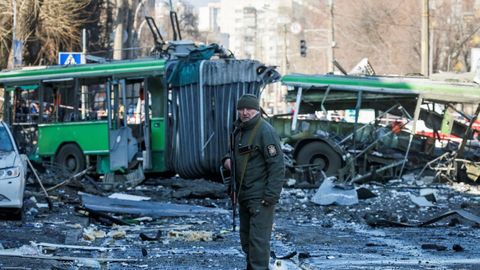 Un agente de policía vigila los alrededores de un edificio destruido por los bombardeos mientras continúa el ataque de Rusia a Ucrania, en Kiev,