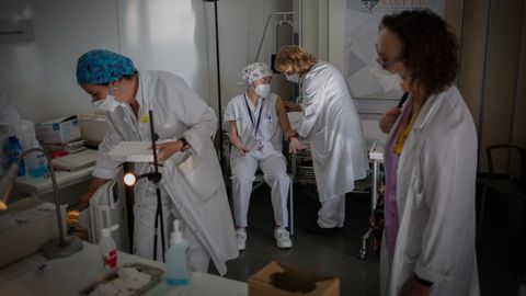Una enfermera vacuna a otro profesional sanitario en un hospital de Barcelona