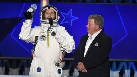El presentador T.J. Miller, vestido de astronauta, junto al actor William Shatner. 
