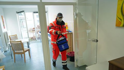 Un trabajador transporta un termo con la vacuna en Alemania