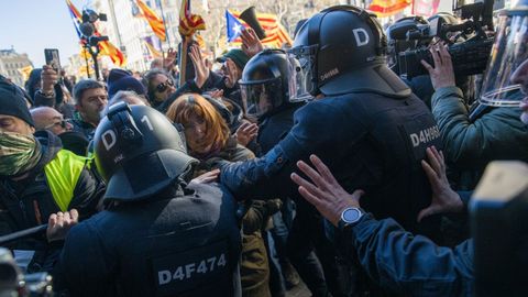 Agentes de los Mossos cargan contra manifestantes independentistas cerca de la plaza Cataluña, en Barcelona