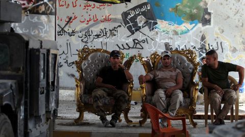 Miembros de la polica de Irak, sentados en un edificio en Faluya, tras haber recuperado la ciudad (Irak).