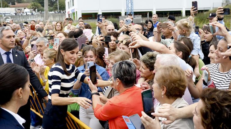 La reina se acercó a saludar a los numerosos vecinos que la despidieron con aplausos, tras aguardar varias horas ante el centro