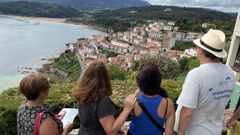 Turistas observan la villa de Lastres desde el mirador de San Roque