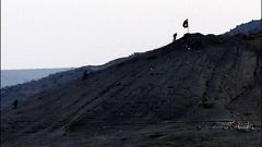 Fotografa hecha desde Turqua que muestra a miembros del Estado Islmico plantando su bandera negra al este de Kobani