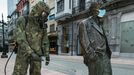 Un soldado desinfecta la estatua de Woody Allen, decorada con una mascarilla, este domingo, en Oviedo