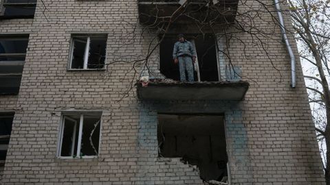 Un hombre se asoma a lo que era el balcón de su apartamento, en Jersón, destruido por las bombas durante un ataque ruso