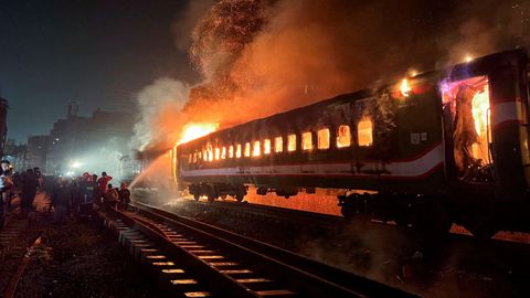 Los bomberos luchan ante un tren en llamas, el viernes en Daca, capital de Banglads.