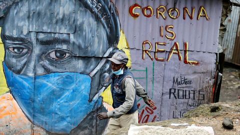 Un hombre pasa delante de un grafiti que alerta sobre el coronavirus en Nairobi
