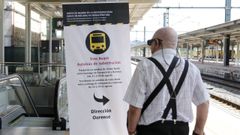 Un usuario observa un cartel que informa del corte de la línea de alta velocidad Santiago-Ourense