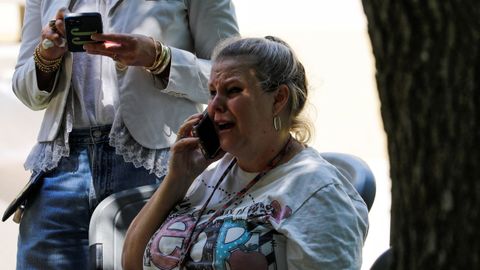 Una mujer habla al teléfono, entre sollozos, en el lugar al que han sido trasladados los alumnos de la Robb Elementary School