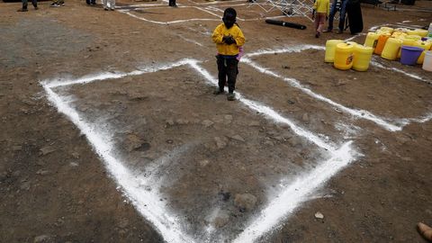En Nairobi han dibujado rectángulos sobre la tierra para marcar la distancia social en un reparto de agua