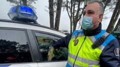 Un polica local de Ribeira, agarrando la mano de Manuel Pego