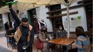 Un camarero escancia sidra en una terraza llena de gente en la Plaza del Fontán en Oviedo