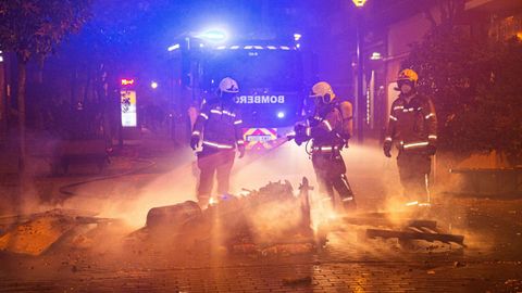 Miembros del cuerpo de bomberos apagan las papeleras quemadas en Logroño 