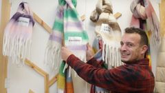 Pablo Lpez muestra alguna de las bufandas que vende en su tienda fsica de Sarria