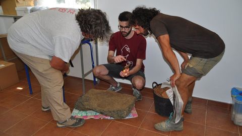 El investigador lvaro Lorenzo centro y los arquelogos Xurxo Ayn e Ivn Aguilera derecha e izquierda examinan la lpida sepulcral descubierta en Vilach de Salvadur