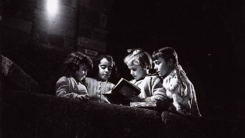 En fecha sin determinar, la imagen de las nias leyendo a la luz de una farola fue tomada en el atrio de la iglesia de Santiago, en la Ciudad Vieja.