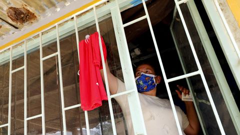  Una nia quita una trapo rojo de su ventana, smbolo con el que se identifican las familias que necesitan comida durante la cuarentena en el municipio de Soacha (Colombia)