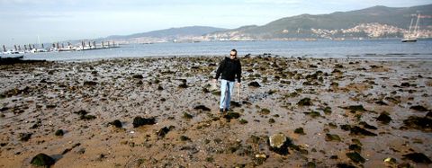 Un agente de la Polica Autonmica arroja al mar las almejas vivas decomisadas ayer en la zona de la playa de Arealonga perteneciente al municipio de Vigo. 