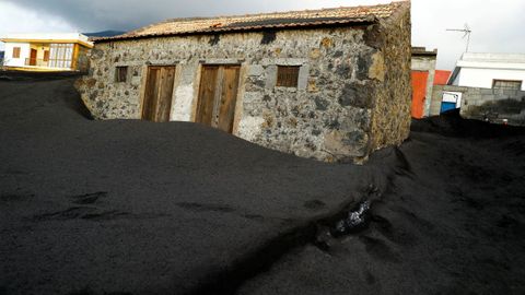 Una casa sepultada por la ceniza del volcán Cumbre Vieja  en el barrio de Las Manchas