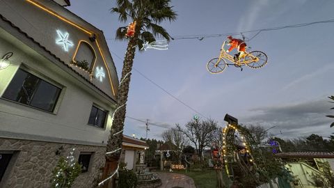 La casa de O Rubio de Cameixa rebosa con detalles, como este Papa Noel en bicicleta, de luces y decibelios de música navideña.