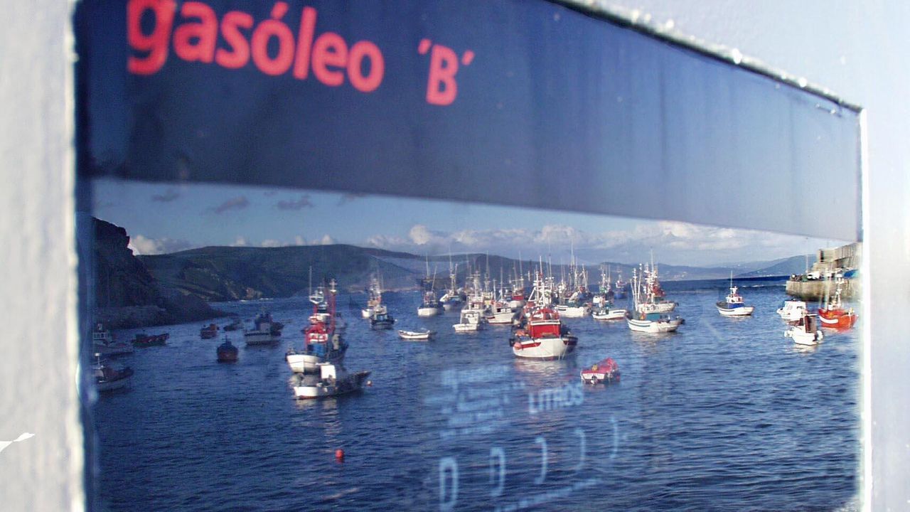 Pesqueros reflejados en un surtidor de combustible en un puerto gallego (foto de archivo)